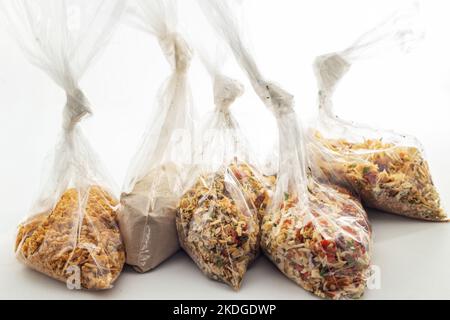 Goiânia, Goias, Brasilien – 06. November 2022: Einige Plastiktüten mit getrockneten Gewürzen auf einer weißen Oberfläche. Stockfoto