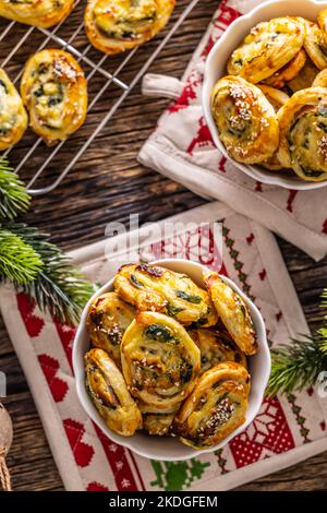 Weihnachtliche herzhafte Backwaren, Mini-Pizzakuchen in einem typischen Weihnachtsgericht und festliche Dekorationen. Stockfoto