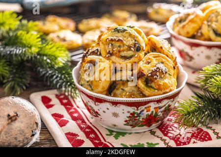 Weihnachtliche herzhafte Backwaren, Mini-Pizzakuchen in einem typischen Weihnachtsgericht und festliche Dekorationen. Stockfoto