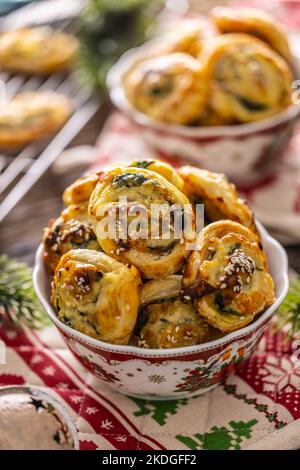 Weihnachtliche herzhafte Backwaren, Mini-Pizzakuchen in einem typischen Weihnachtsgericht und festliche Dekorationen. Stockfoto