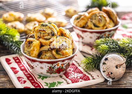 Weihnachtliche herzhafte Backwaren, Mini-Pizzakuchen in einem typischen Weihnachtsgericht und festliche Dekorationen. Stockfoto