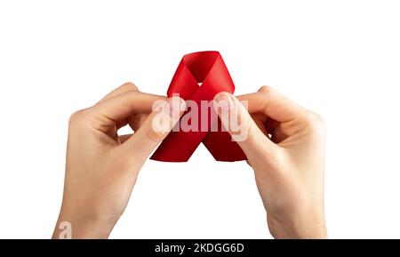 Rotes Satinband in der Hand isoliert auf weißem Hintergrund. Symbol für den Tag des HIV- und AIDS-Bewusstseins. Hochwertige Fotos Stockfoto