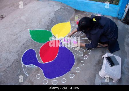 Stammesvolk, das am Vorabend von Diwali Rrangoli zieht Stockfoto