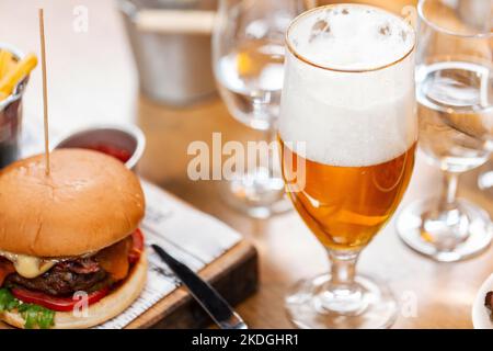 Nahaufnahme von Bierglas und Burger im Restaurant Stockfoto