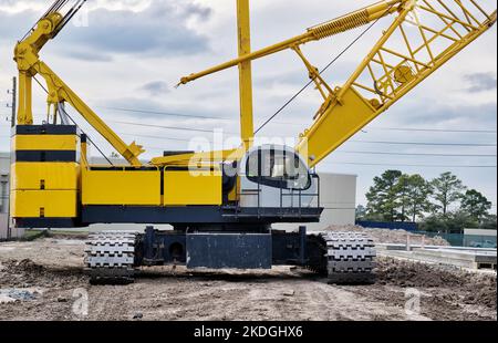 Raupenkrane isolierte Frontansicht auf einer Baustelle mit Fokus auf Maschinendeck, Gegengewicht und Trittflächen. Stockfoto