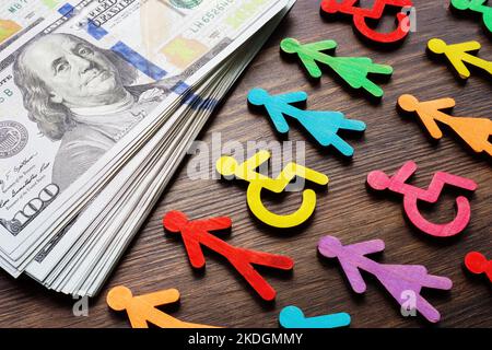 Bunte Figuren und Geld. Einkommensungleichheit und Lohngefälle. Stockfoto