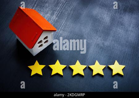 Modell der Heimat und fünf Sterne. Konzept der Immobilienbewertung. Stockfoto