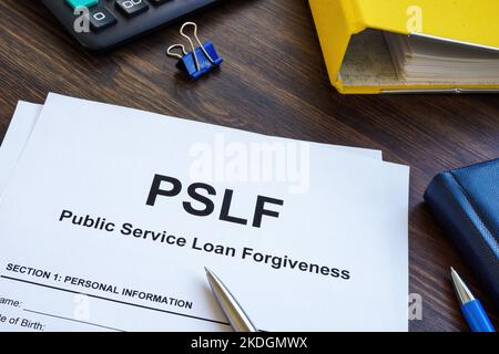 Papiere foe Public Service Loan Forgiveness PSLF auf der Holzoberfläche. Stockfoto