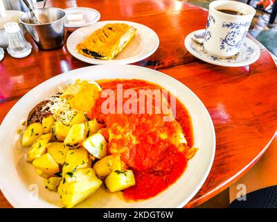 Mexikanisches Omelett mit schwarzen Bohnen Kartoffeln und Nachos auf weißem Teller in El Cafecito in Zicatela Puerto Escondido Oaxaca Mexiko. Stockfoto