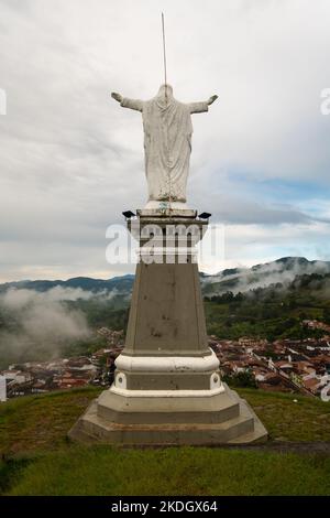 Jerico, Antioquia, Kolumbien - April 4 2022: Hohe weiße Statue von Jesus Christus auf einem Hügel gegen den blauen Himmel Stockfoto