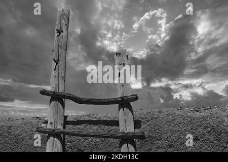 Traditionelle Holzleiter auf Adobe südwestlichen Architektur mit Nachmittagsregen zieht ein. Stockfoto