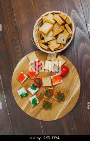 Fleisch auf getoastetem Brot mit Gemüse verteilen. Frische, leckere Croutons aus Vollkornbrot Stockfoto