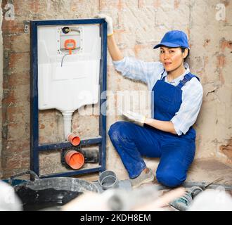 Klempner in der Nähe von an der Wand befestigten Toilettensystemen Stockfoto