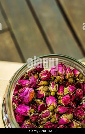 Ein Glasbehälter, gefüllt mit getrockneten Rosenknospen, um Tee zuzubereiten Stockfoto