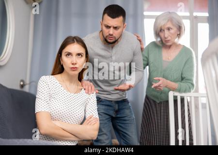 Mann und reife Frau schelten junge Frau Stockfoto