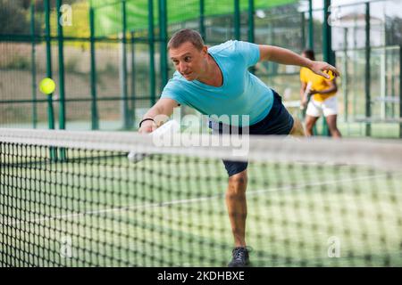 Mann spielt Padel Tennis auf dem Platz Stockfoto