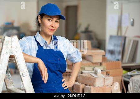 Baumeisterin posiert auf der Baustelle im Innenbereich Stockfoto