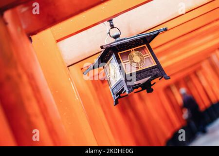 Rotes Tori-Tor am Fushimi Inari-Schrein in Kyoto, Japan. Selektiver Fokus auf die traditionelle japanische Schrift. Stockfoto