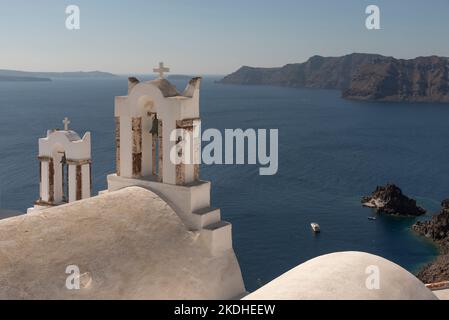 Oia, Santorini, Griechenland. 2022. Die Glocken der orthodoxen Kirche Panagia Agion Panton mit Blick auf die Ägäis Stockfoto