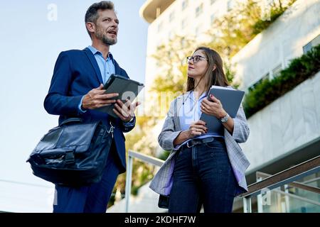 Junge Geschäftspartner im Gespräch vor dem Bürogebäude Stockfoto