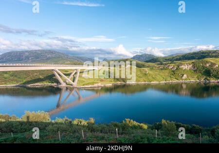 Markante moderne geschwungene, gewundene Betonkastenbrücke, die den Loch A' Chàirn Bhàin in Sutherland überquert. Vor Sonnenuntergang Sommersonne, blauer Himmel und Stockfoto