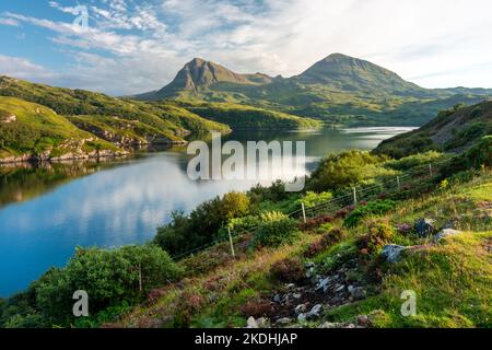 Markante moderne geschwungene, gewundene Betonkastenbrücke, die den Loch A' Chàirn Bhàin in Sutherland überquert. Vor Sonnenuntergang Sommersonne, blauer Himmel und Stockfoto