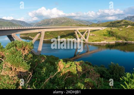 Markante moderne geschwungene, gewundene Betonkastenbrücke, die den Loch A' Chàirn Bhàin in Sutherland überquert. Vor Sonnenuntergang Sommersonne, blauer Himmel und Stockfoto