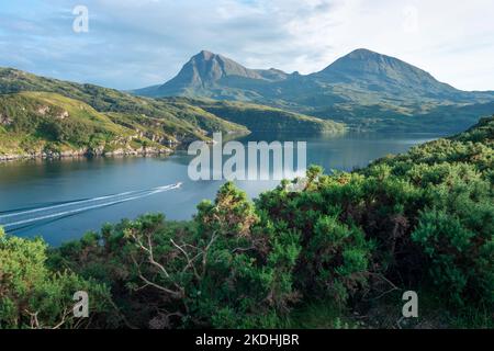 In der Nähe der Kylesku-Brücke, über die Bhàin in Sutherland, mit dem Schnellboot über das spiegelglatte loch-Wasser, wunderschöne sonnenbeschienene Berge und grüne Umgebung Stockfoto