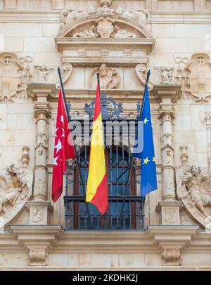 Die Flaggen von Madrid, Spanien und der Europäischen Union fliegen vor einem Gemeindegebäude in Spanien Stockfoto