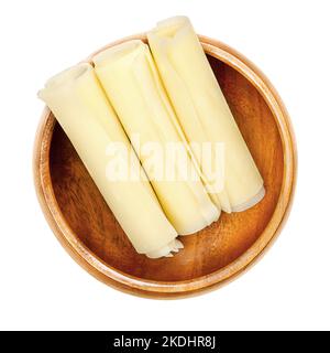 Sbrinz, Schweizer Hartkäse-Brötchen, in einer Holzschale. Drei dünne, gerollte Scheiben extra hartem Vollfettkäse, hergestellt in der Zentralschweiz. Stockfoto