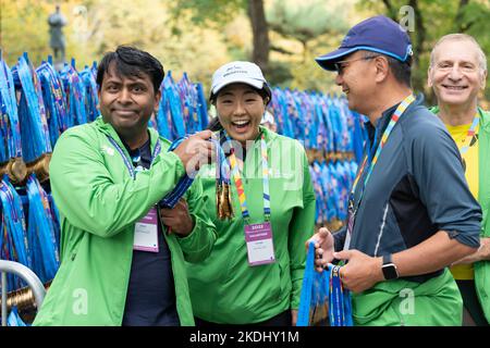 New York, USA. 06.. November 2022. Freiwillige helfen den Finishern des 51. TCS NYC Marathons mit ihren Medaillen im Central Park in New York am 6. November 2022. Das für die Saison unwetterbare heiße und feuchte Wetter beeinflusste viele Läufer und schuf ungesunde Bedingungen. (Foto von Lev Radin/Sipa USA) Quelle: SIPA USA/Alamy Live News Stockfoto