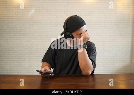 Weinen, während Sie Musik mit Kopfhörern hören Stockfoto