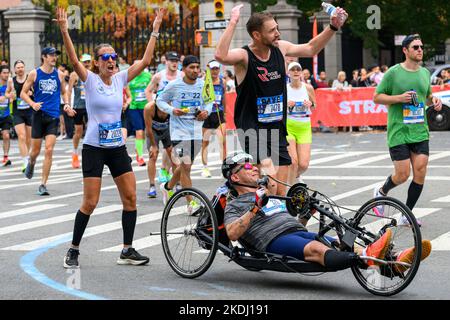 New York, USA. 6.. November 2022. Läufer bitten Zuschauer, den Rollstuhlfahrer Offir Maimon aus Israel anzufeuern, wenn sie während des TCS New York City Marathon in den Central Park eintreten. Kredit: Enrique Shore/Alamy Live Nachrichten Stockfoto