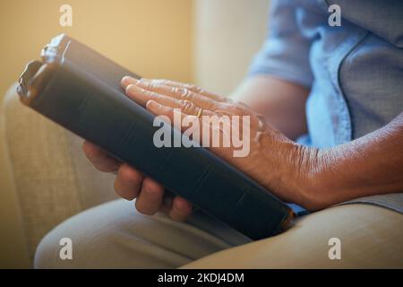 Seine Stütze der Stärke. Nahaufnahme einer älteren Frau, die zu Hause eine Bibel hält. Stockfoto