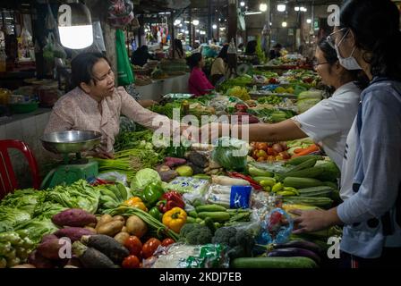 Frauen kaufen Gemüse von einem Stallholder auf dem Siem Reap Central Market in Kambodscha. Stockfoto