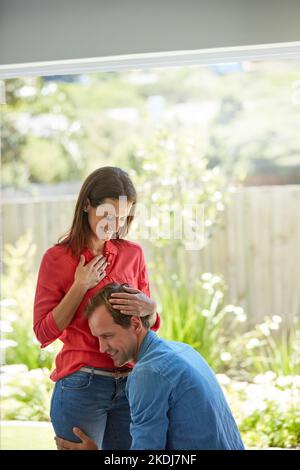 Eltern zu werden, ist die größte Nachricht, die sie immer wollten. Ein Mann drückt sein Ohr auf seine Frau, den schwanger Bauch zu Hause. Stockfoto