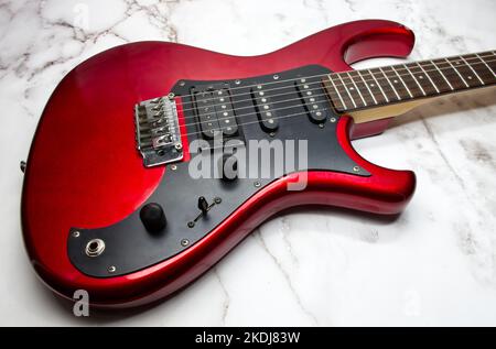 Rote E-Gitarre isoliert auf Marmor Hintergrund Stockfoto