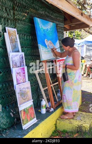 Eine Frau, die eine Meeresschildkröte auf dem Punanga Nui Markt in Rarotonga, Cook Islands, malt Stockfoto