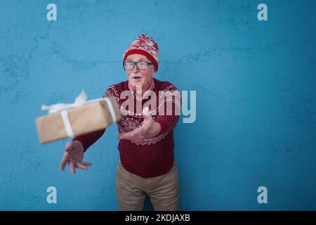 Porträt eines glücklichen älteren Mannes, der ein Geschenk anfängt, Studioaufnahmen. Stockfoto
