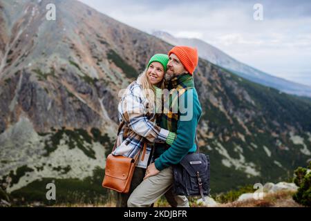 Junges, glückliches Paar auf einer Bergwanderung, das sich umarmt. Stockfoto