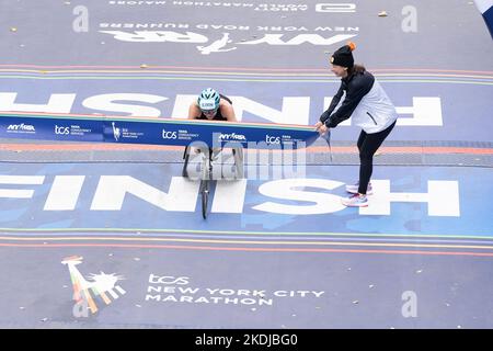New York, New York, USA. 6.. November 2022. Susannah Scaroni von der US-Siegerin mit dem 1.. Platz in der Women Wheelchair Division überquert die Ziellinie beim 51. TCS NYC Marathon im Central Park. Für den Marathon lief sie 1:42:43 Stunden. Das für die Saison unwetterbare heiße und feuchte Wetter beeinflusste viele Läufer und schuf ungesunde Bedingungen. (Bild: © Lev Radin/Pacific Press via ZUMA Press Wire) Stockfoto