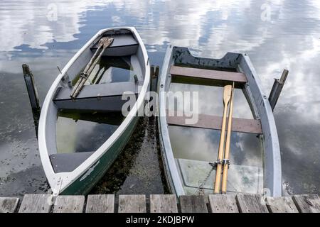 Zwei kleine Schiffswracks voller Wasser auf einem See Stockfoto