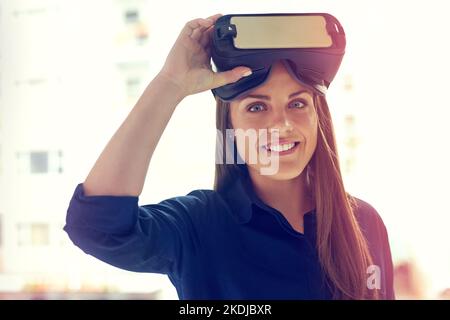 Ändern Sie die Art und Weise, wie Sie die Welt betrachten. Porträt einer jungen Geschäftsfrau, die ein VR-Headset in einem Büro trägt. Stockfoto
