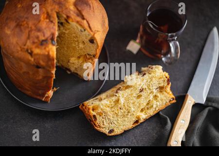 Panettone-Weihnachtskuchen. Italienisches süßes Brot auf dem schwarzen Kichen-Tisch. Stockfoto