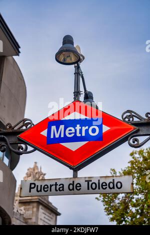 Madrid, Spanien - 30. Oktober 2022: Nahaufnahme des Metro-Schildes vor der Puerta de Toledo U-Bahnstation in Madrid, Hauptstadt von Spanien, selektiver Fokus. Stockfoto