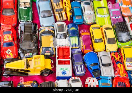 Sammlung von alten bunten Miniatur-Autos entlang einer Straße Flohmarkt. Stockfoto