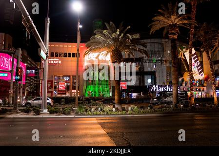 Verschiedene beleuchtete Geschäfte in modernen Gebäuden auf der Straße in der berühmten Stadt bei Nacht Stockfoto