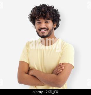 Porträt eines glücklichen asiatischen Mannes mit lockigen Haaren und weißen Zähnen in einem gelben T-Shirt, das auf weißem Hintergrund steht Stockfoto