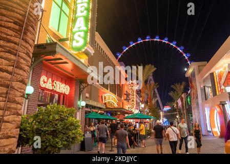 Touristen, die nachts die beleuchtete LINQ-Promenade in der berühmten Stadt erkunden Stockfoto
