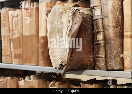 Alte abgenutzte Bücher aus dem 17. Jahrhundert auf einem Regal in der Archive der Bibliothek Stockfoto